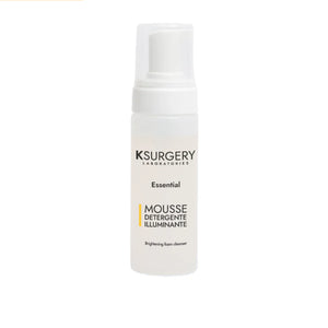 „KSurgery Mousse Detergente Illuminante“ – šviesinamosios veido putos baltame buteliuke su dozatoriumi, skirtos veido valymui ir odos skaistinimui.